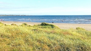 A beach with grassy dunes and a clear sky. - 8 Person Holiday Home in Skummeslovsstrand (Skummesloevsstrand)