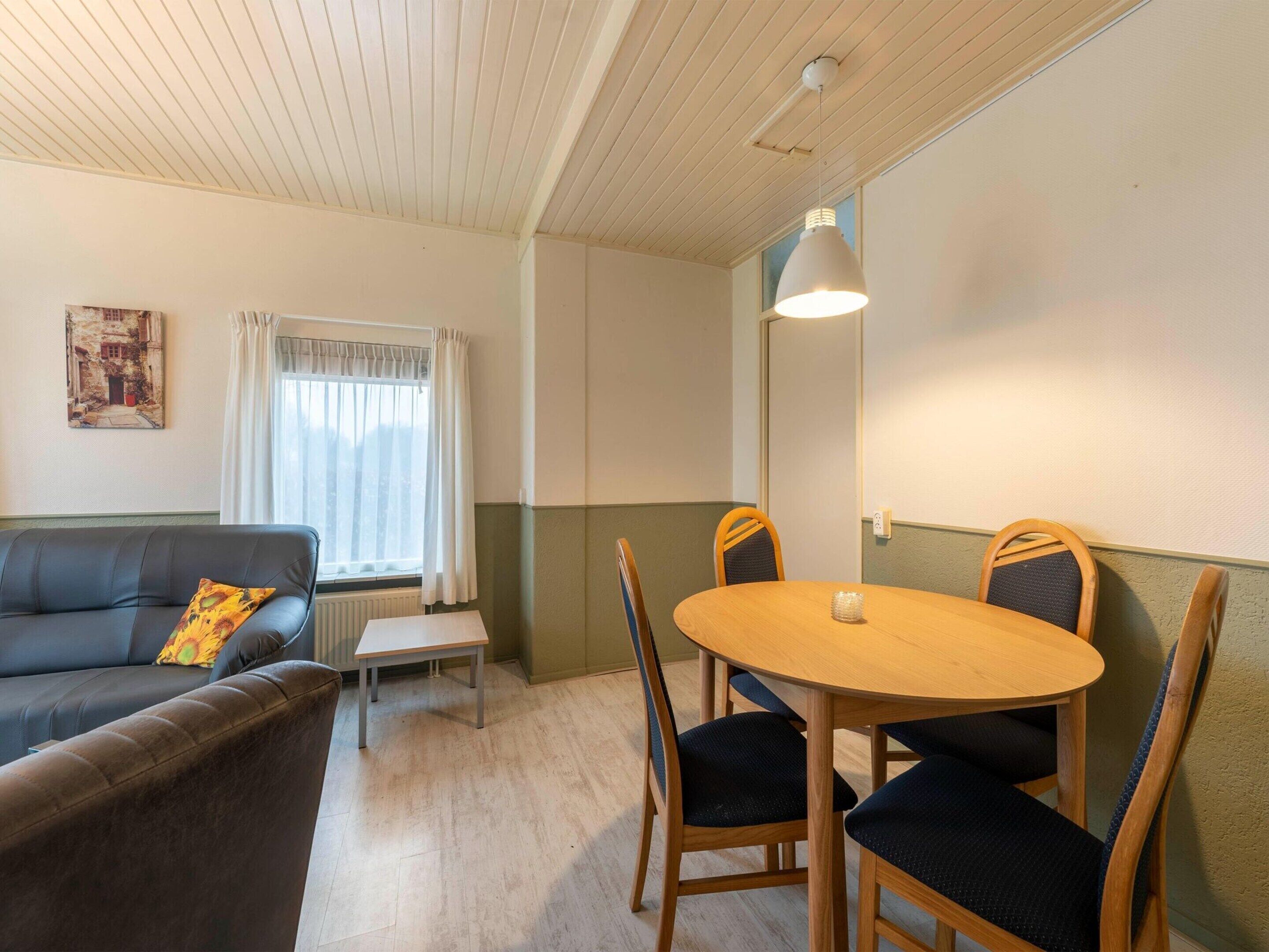 Un salon confortable avec un canapé, une petite table et une table à manger avec des chaises.