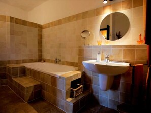 A modern bathroom with a freestanding bathtub, a large sink, and a mirror above the sink.