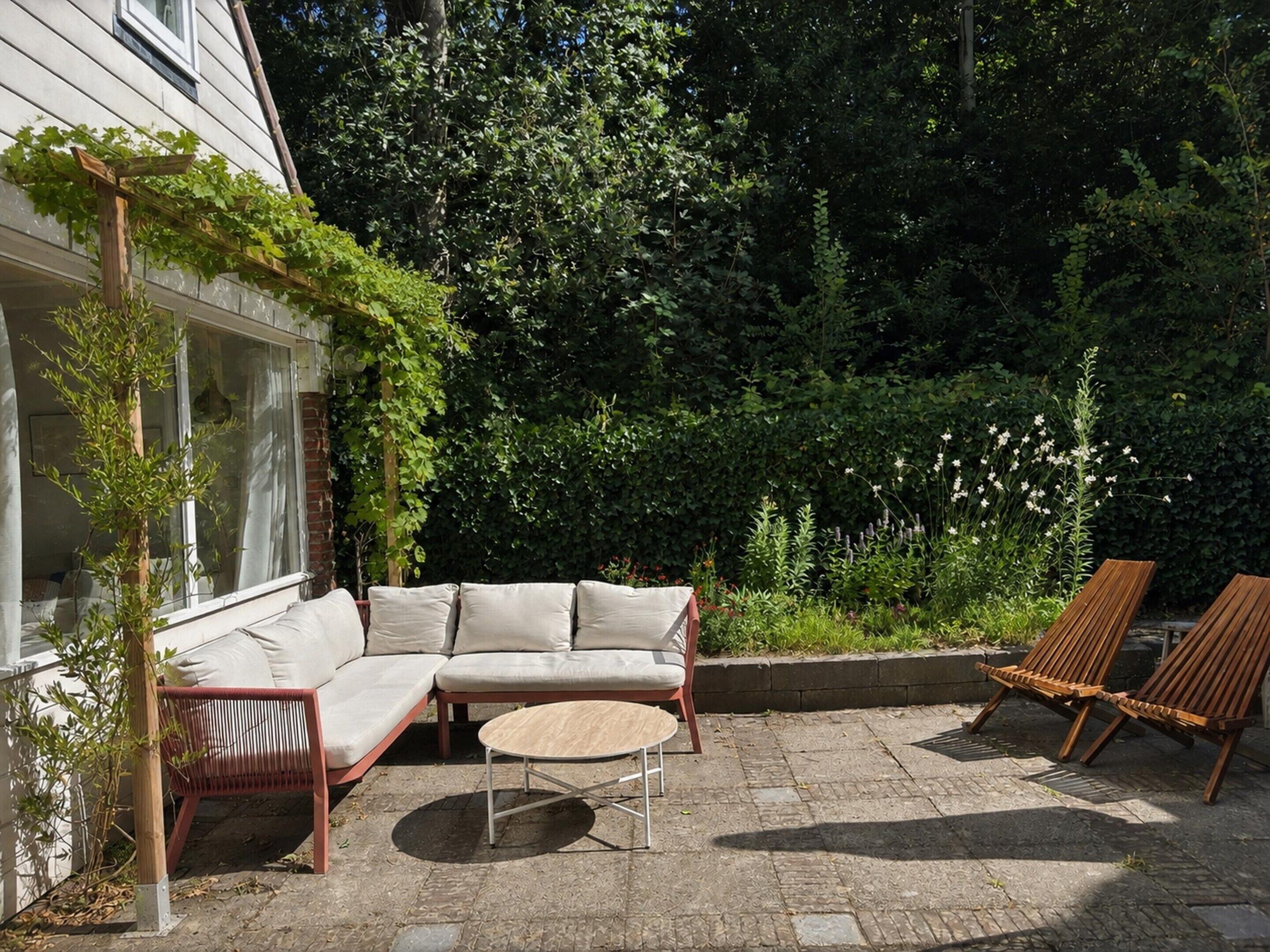 Une terrasse avec un canapé, des chaises et une table.