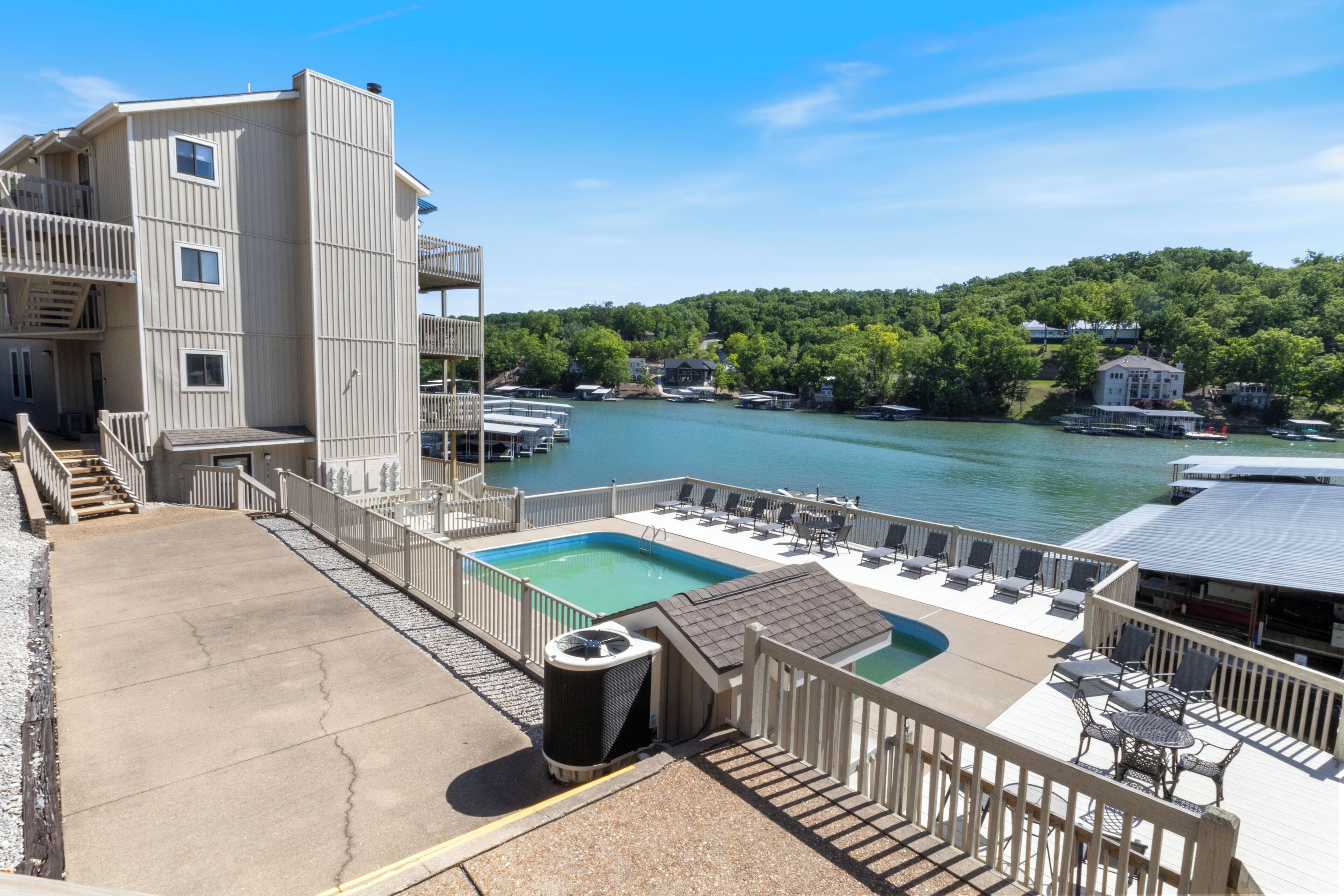 A pool area with a view of a river and a forested hill.