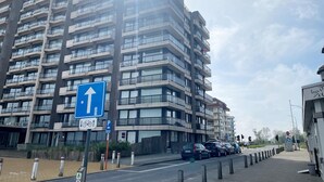 Un immeuble résidentiel à plusieurs étages, doté de balcons, avec un ciel dégagé.