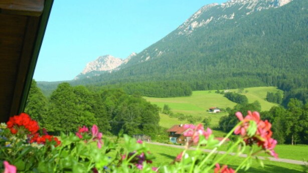 Eine Berglandschaft mit einem Haus im Tal.