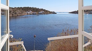 A view from a window overlooking a calm body of water with houses on the shore. - 12 Person Holiday Home in Lyngor (Tvedestrand)