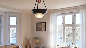 A dining area with a wooden table, white chairs, a globe, and a lamp. - 12 Person Holiday Home in Lyngor (Tvedestrand)