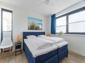 A bedroom with a bed, a chair, a small table, a ceiling fan, and a window with curtains. - Water Villa With Jetty and 3 Leisure Boats (Zeewolde)