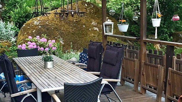 A wooden deck with a table and chairs, surrounded by a wooden fence and lush greenery. - 8 Person Holiday Home in Brottby-by Traum (Brottby)