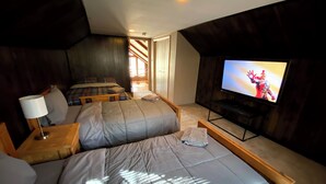 A bedroom with two beds, a TV, and a wooden headboard. - Eat, Sleep, Ski. Repeat.  (Lake Harmony)