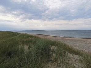 Una playa con dunas de arena y vista al océano.