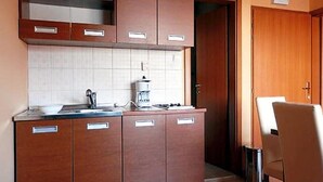 Una cocina compacta con armarios de madera, una encimera y una cafetera.