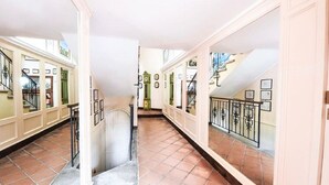 A corridor with tiled flooring, a staircase, and a door leading to another room. - Belvilla by OYO Villa Teodora (Anguillara Sabazia)