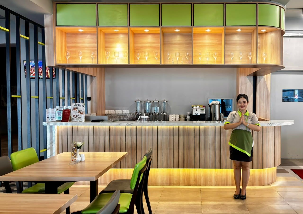 A restaurant interior with a counter, seating area, and a barista.