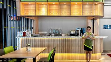 A restaurant interior with a counter, seating area, and a barista.
