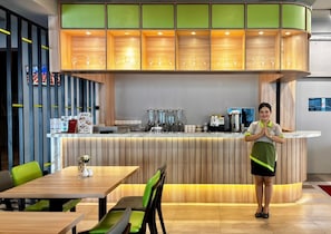 A restaurant interior with a counter, seating area, and a barista. - MaxOne Dumai (Dumai)
