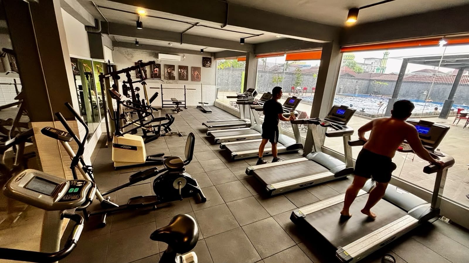 Une salle de sport équipée de tapis de course, de vélos d’appartement et d’appareils de musculation.
