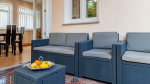 A modern outdoor seating area with wicker furniture and a fruit bowl. - Andrea Comfortable Holiday Residence (Marcana)