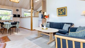En modern inredning med matplats, soffa och kök.
