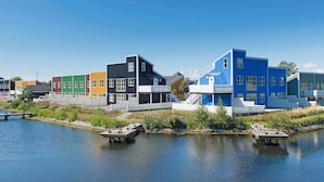 Propiedad frente al agua con edificios de colores, un muelle y un lago tranquilo.
