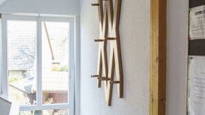 A room with a large window, a wooden ladder leaning against the wall, and a bulletin board with papers. - Holiday Apartment Sauer Large (Varel)