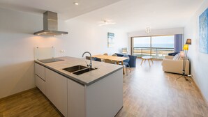 A modern kitchen with a central island, a dining area with a view, and a living space with a balcony. - Seaside Stay Middelkerke (Middelkerke)