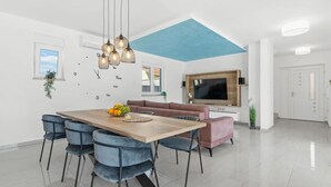 Un comedor moderno con una mesa de madera, sillas azules e iluminación colgante.