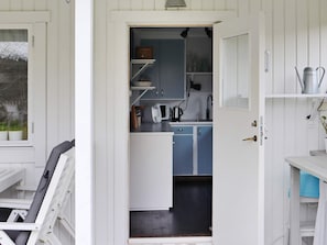 A compact kitchen with white cabinets, a blue countertop, and a kettle on the counter. - 4 Person Holiday Home in Varberg (Varberg)