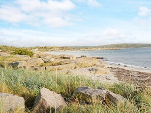 A coastal landscape with large rocks, grassy areas, and a calm sea. - 4 Person Holiday Home in Varberg (Varberg)