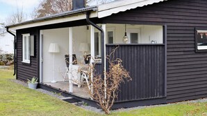 A modern house with a covered porch, a small garden, and a visible window. - 4 Person Holiday Home in Varberg (Varberg)