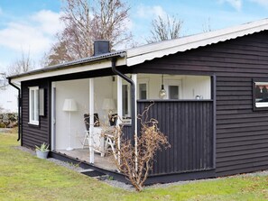 A modern house with a covered porch, a small garden, and a visible window. - 4 Person Holiday Home in Varberg (Varberg)