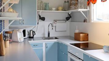 Una cocina con pileta, estufa y alacenas.