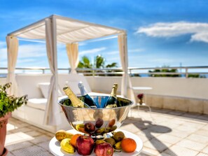 A table with a fruit bowl and champagne bottles on a terrace with a view of the sea. - Belvilla by OYO Apartamento 2dormitorios (Arona)