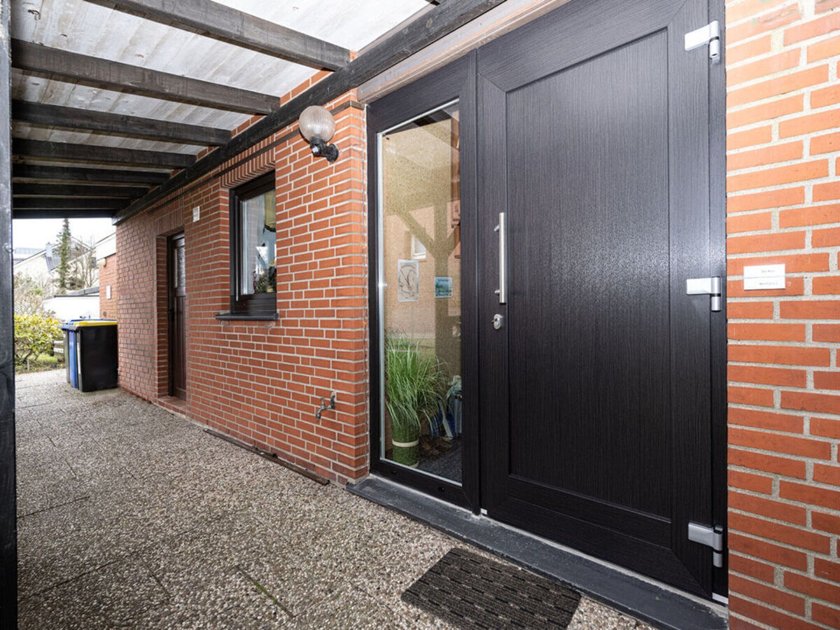 A brick building with a dark wooden door and a window.