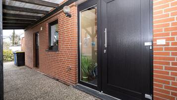 A brick building with a dark wooden door and a window.