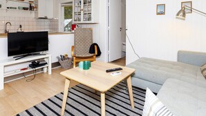 A compact living space with a television, a dining table, a sofa, and a kitchen area. - 6 Person Holiday Home in Hals (Hals)
