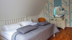 Ein Schlafzimmer mit einem Bett, einem Nachttisch, einem Sessel und einer Kommode.