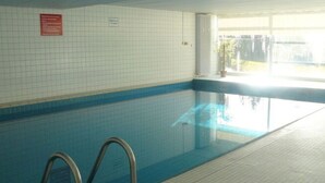 An indoor swimming pool with tiled walls and a clear view of the outside. - Waldresidenz Comfortable Holiday Residence (Unterkirnach)