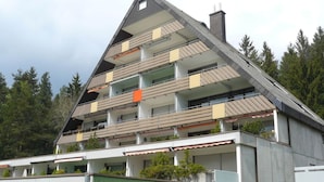 A multi-story building with a sloped roof, balconies, and a chimney. - Waldresidenz Comfortable Holiday Residence (Unterkirnach)