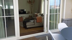 A modern living room with a sofa, coffee table, and a TV. - Apartment in Nieuwpoort for 6 Persons (Nieuwpoort)