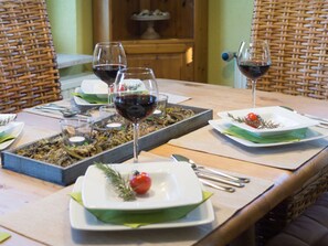Ein Esstisch ist gedeckt mit Tellern, Gläsern und einer Platte mit Essen.