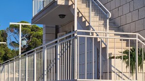 A modern building with a concrete facade, a metal staircase with a railing, and a security camera. - Apartment Solvit - Three Bedroom Apartment With Terrace (Dubrovnik)