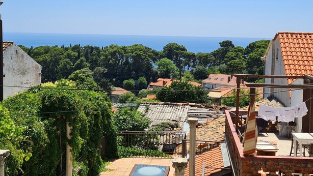 A coastal residential area with terracotta roofs, a swimming pool, and a view of the sea. - Apartment Solvit - Three Bedroom Apartment With Terrace (Dubrovnik)