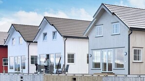 A row of modern, single-story houses with large windows and a wooden deck in front. - 6 Person Holiday Home in Bud (Averoy)