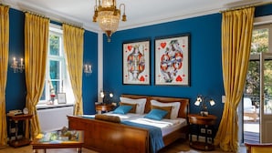A bedroom with a large bed, two bedside tables, a chandelier, and artwork on the wall. - Villa _master Suite Comfortable Vacation Home (Ilsenburg)