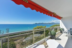 Un balcón con vista despejada al mar y montañas a lo lejos.