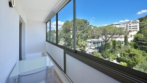Een balkon met vrij uitzicht op een weelderig groen landschap en gebouwen in de verte.