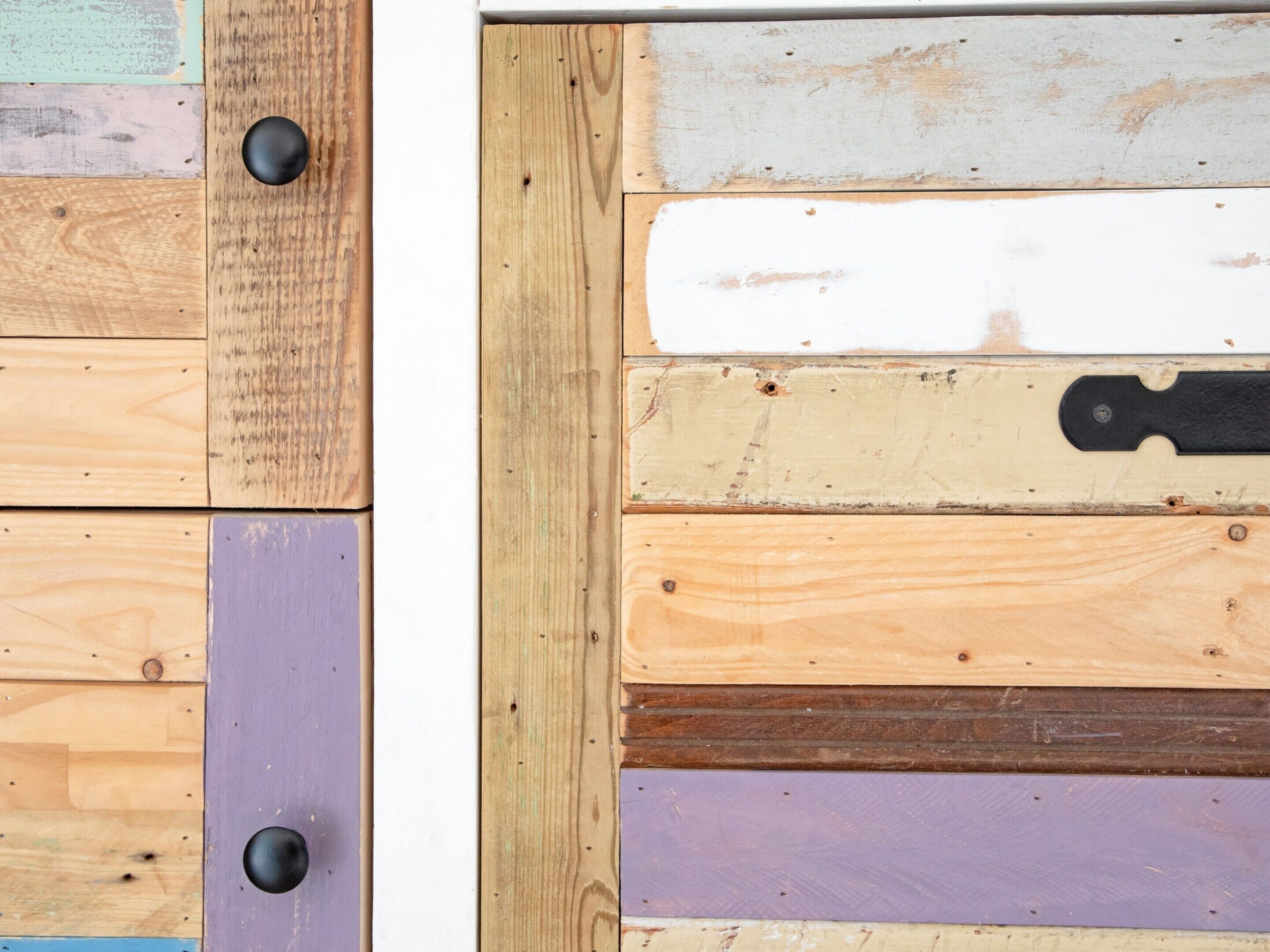 A wooden door with multiple panels in various colors and textures.