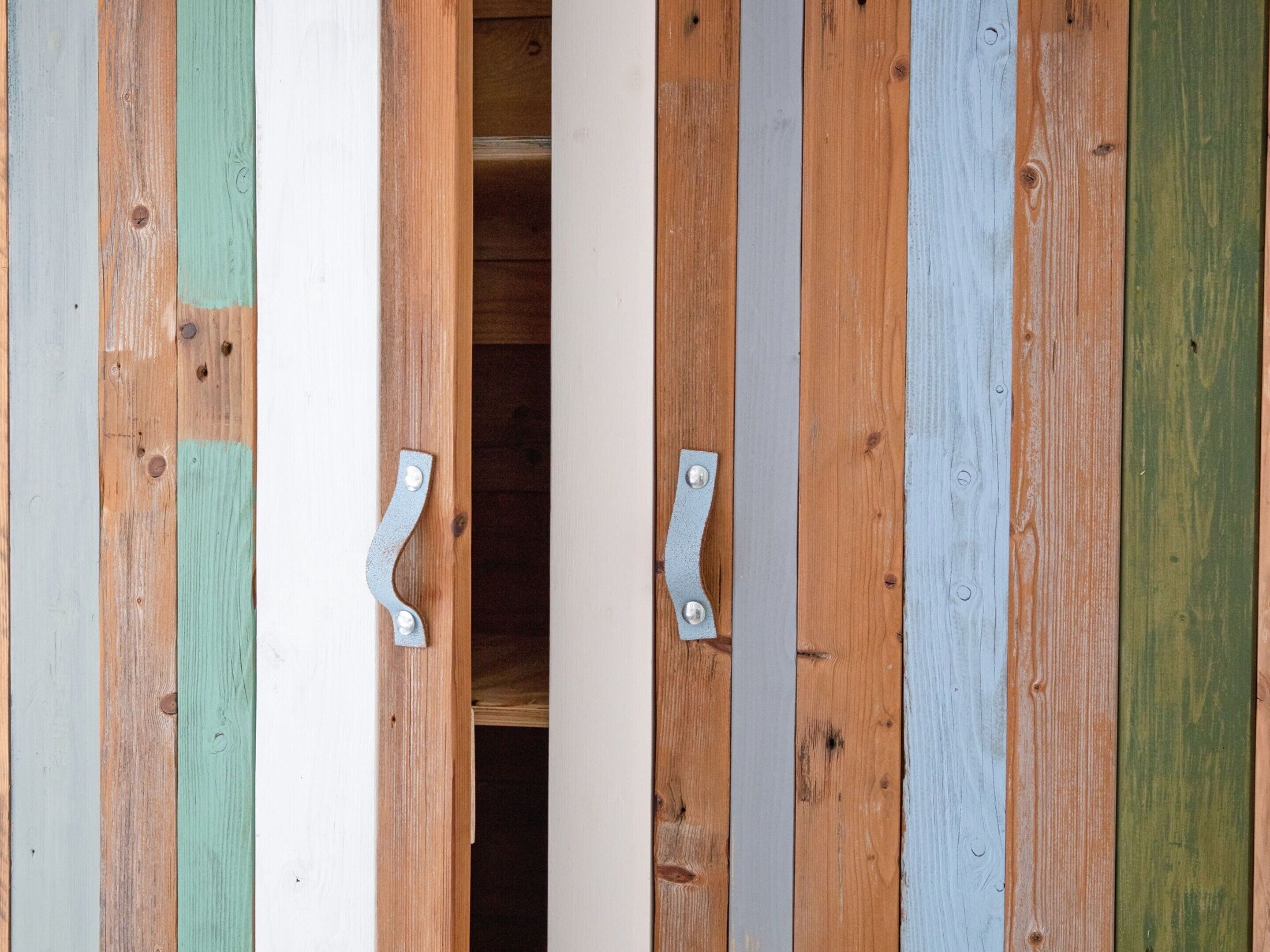 A wooden door with two metal handles.