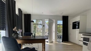 A modern kitchen with white cabinets and a built-in oven. - Sartoris Comfortable Holiday Residence (Bad Neuenahr-Ahrweiler)