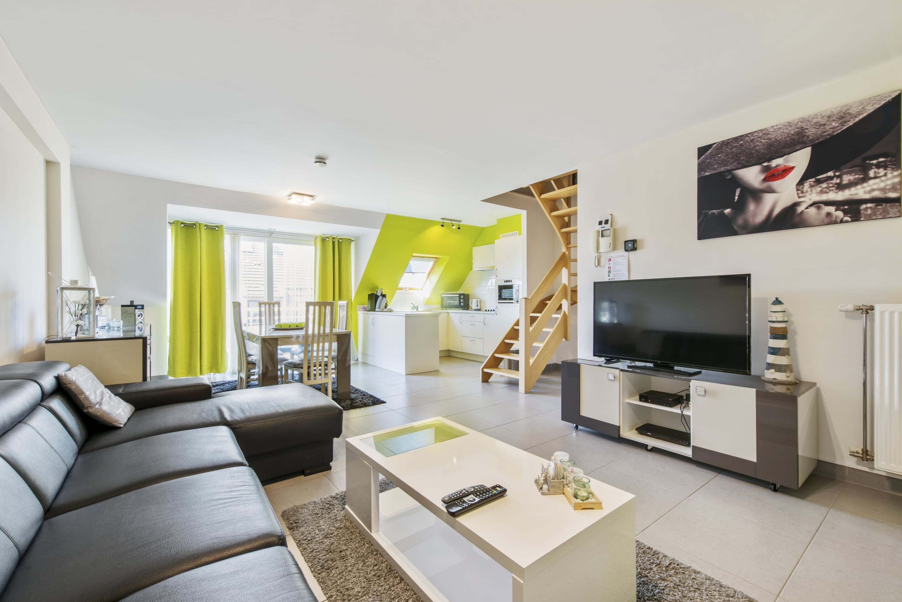 Ein modernes Wohnzimmer mit einer schwarzen Ledersofa, einem weißen Couchtisch und einem Fernsehschrank.