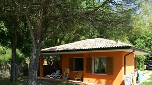 A small, single-story building with a tiled roof, surrounded by trees and grass. - Luxurious Bungalow in Garda With Swimming Pool (Garda)